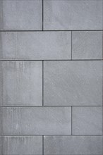 Wallcovering of large dark gray natural stone tiles
