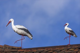White stork figures on a roof