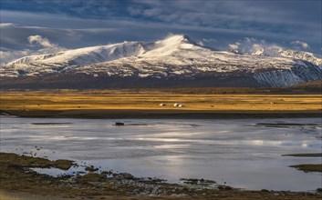 Khurgan Lake with snow-covered mountains in the back