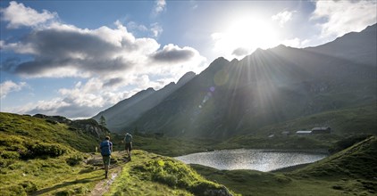 Hikers at the Unterer Giglachsee with morning sun