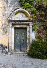 Weathered entrance door with climbing roses