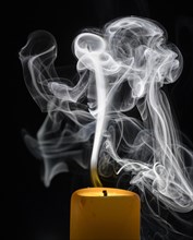 Smoky candle in front of a black background