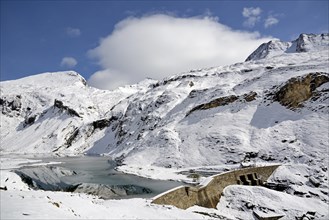 Nassfeld reservoir with dam at 2233 m on the Grossglockner High Alpine Road with snowy mountains