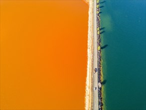 Street trough orange and blue lakes in mining region