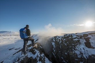 Mountain hiker stands at Continental Rift between North American and Eurasian Plate