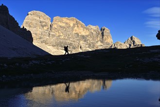 Hiker on the lake in the backlight