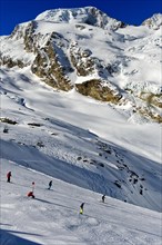 Skiers on the Langfluh ski slope in front of the snow-covered Alphubel