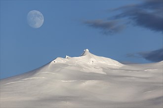 Snow-covered Snaefell volcano with Snaefellsjokul glacier and full moon