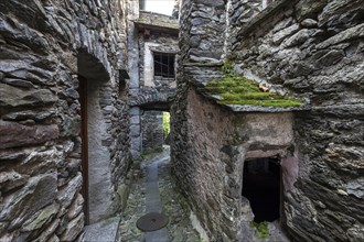 Typical Ticino stone houses in a narrow alleyway in the mountain village of Bordei