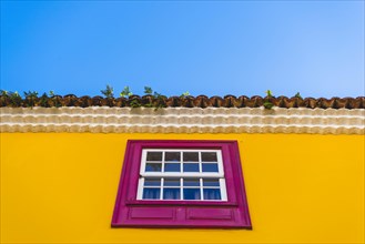 Yellow facade with pink window