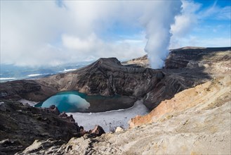Steaming fumarole with crater lake on the Gorely volcano