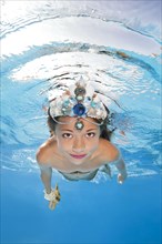 Girl in a mermaid costume poses underwater