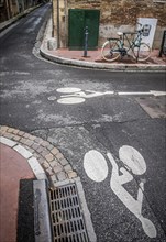 Bicycle parks next to a road surface marking for bicycle lane on a street, Toulouse