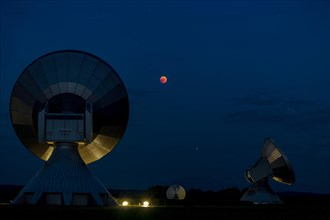 Parabolic antennas with blood moon at lunar eclipse