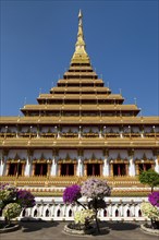 Flowering bushes in front of nine-story stupa Phra Mahathat Kaen Kakhon