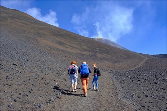 Hikers climbing through volcanic landscape
