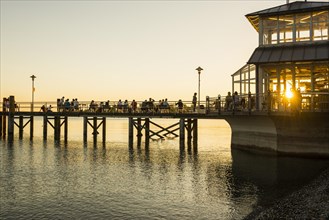 People on footbridge at sunset