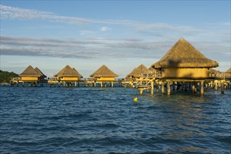 Overwater bungalows on stilts in luxury hotel