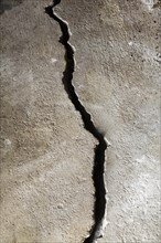 Close-up of a half-inch crack in a poured cement floor