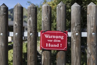 Red warning sign on garden fence
