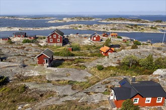 Red wooden houses on the rocky coast