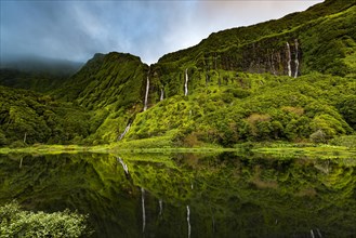 Waterfalls with lake Poco Ribeira do Ferreiro in green landscape