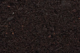 Organic potting soil mix enriched with compost abstract background texture closeup of particles
