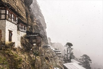 Buddhist nunnery in the mountains during snowfall
