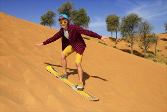 Tourist with Snowboard on the Dune