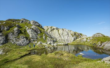 Two hikers at a small lake