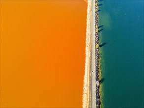 Street trough orange and blue lakes in mining region