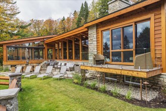 Rear view of luxurious stained cedar and timber wood home with panoramic windows