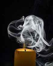 Smoky candle in front of a black background