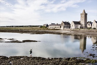 Angler in the mud flats in front of the village of Portbail