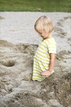 Toddler with 3 years on a playground in the sandbox