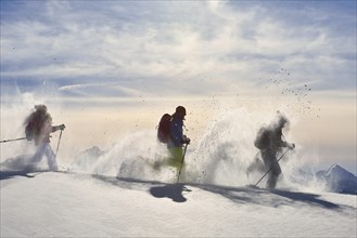Three snowshoe walkers walking in the snow