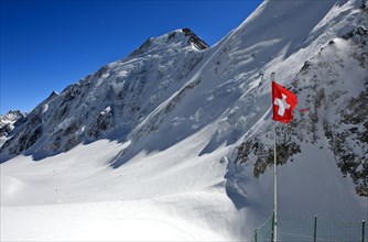 Swiss flag in front of Aletschhorn with snow