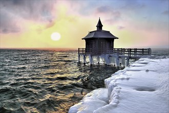 Bathhouse on pier with icicle in winter at sunrise