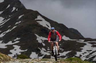 Mountain bikers in front of mountain peak