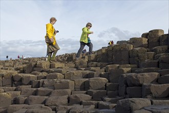 Tourists walk on the basalt columns