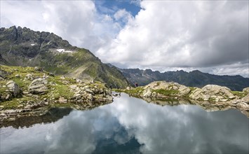 Hikers are reflected in a lake