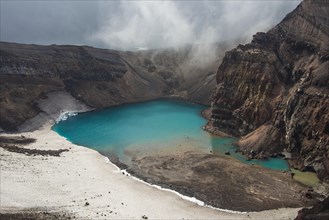 Steaming fumarole with crater lake on the Gorely volcano