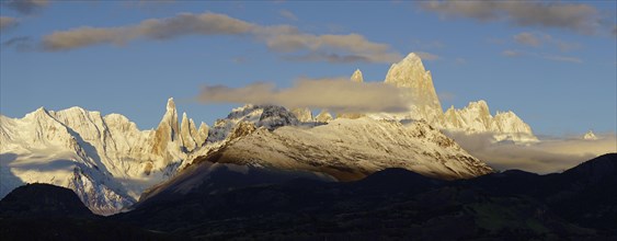 Snow-covered mountain range with Cerro Torre and Fitz Roy at sunrise