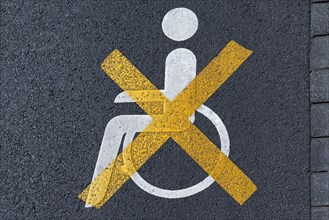 Crossed out disabled sign on a parking lot