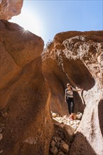 Young female hiker in a narrow sandstone canyon