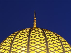 Illuminated dome of the Great Sultan Qabus Mosque at night