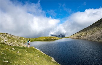 Hiker at Sattelsee lake at Greifenbergsattel