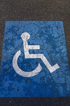 Sign for parking for people with disabilities on torn tar