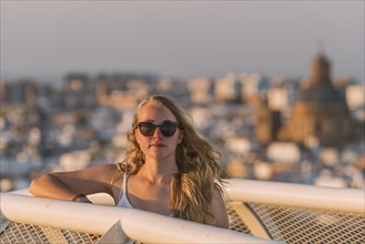 Young woman in sunglasses looks into the camera