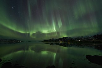 Aurora borealis with water reflection in the fjord